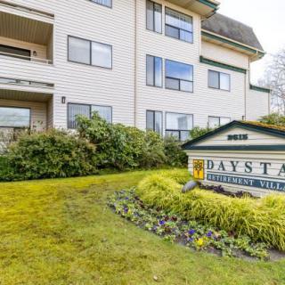 A residential apartment building with a landscaped entrance and a sign displaying the name 'Daystar'.