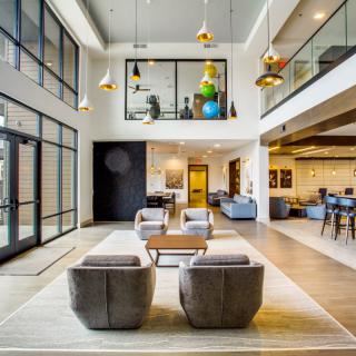A modern lobby featuring a spacious seating area with stylish furniture and contemporary lighting.