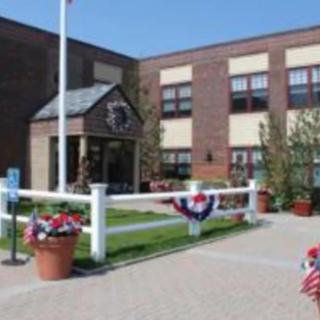 A brick school building decorated with patriotic flags and banners.