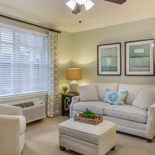 A cozy living room with a comfortable sofa, armchair, and natural lighting.