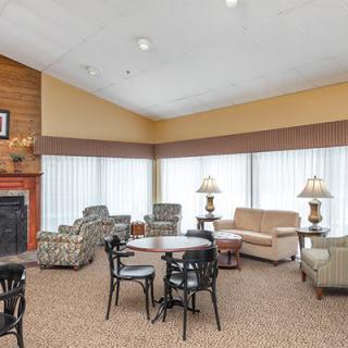 A cozy living room with comfortable seating, a fireplace, and tables.