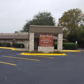 An entrance to Oak Farms Dairy with a visible sign and adjacent parking lot.