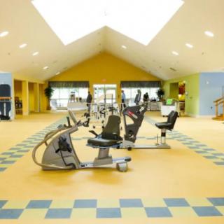 A spacious and well-lit gym with modern exercise equipment.