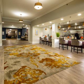 A spacious hotel lobby with a decorative carpet and seating area.