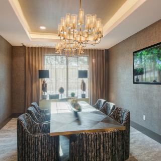 A modern and elegant dining room featuring a chandelier and stylish furnishings.