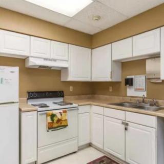 A clean and modern kitchen with white cabinetry and standard appliances.