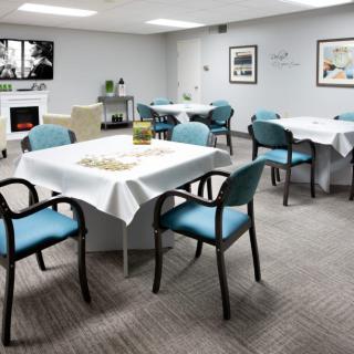 An inviting dining room with neatly arranged tables and chairs, featuring modern decor and artwork on the walls.
