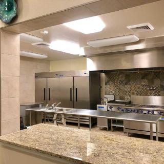 A view of a modern commercial kitchen with stainless steel appliances and a clean, spacious layout.