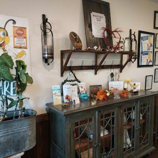A cozy interior wall featuring a blend of decorative items, plants, and artwork.
