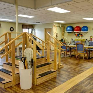 A well-equipped rehabilitation center featuring a set of stairs for physical therapy exercises and various fitness tools.