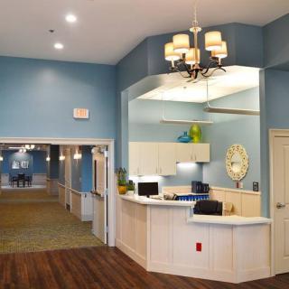 A well-lit reception area with a desk, hallway, and charming decor.