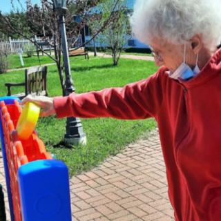 An elderly person enjoying an outdoor game on a sunny day.