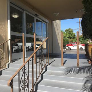 A view of the entrance with steps and railings leading into a building.