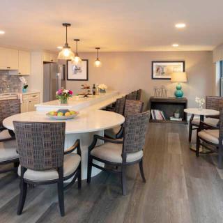 A modern open-concept kitchen and dining area with stylish lighting and wood flooring.