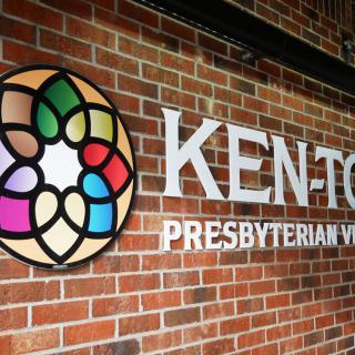 A sign on a brick wall displaying the name and logo of Ken-Ton Presbyterian Village.
