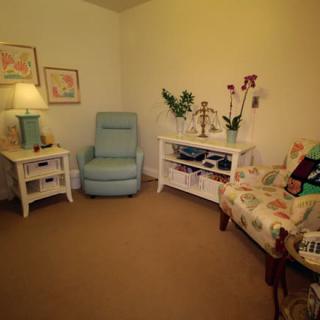 A cozy living room with a light blue armchair, decorated tables, and warm lighting.