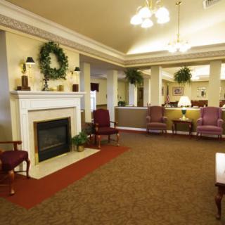 A cozy lobby area featuring a fireplace, comfortable seating, and decorative plants.