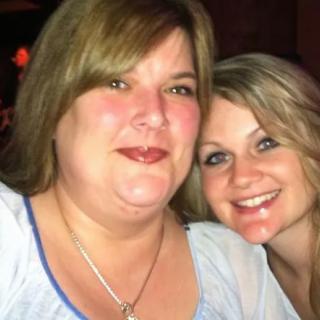 Two women smiling together indoors.