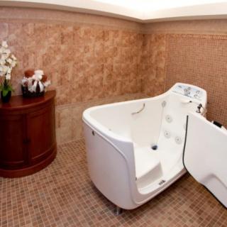 A luxurious bathroom featuring a walk-in bathtub and elegant tile walls.