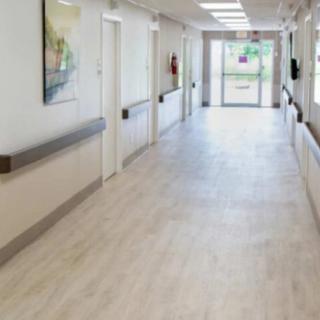 An empty hospital corridor with bright lighting.