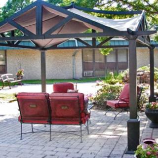 A cozy outdoor patio area with a pergola and seating arrangements.