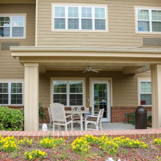 A cozy outdoor patio area featuring seating and a beautiful garden.