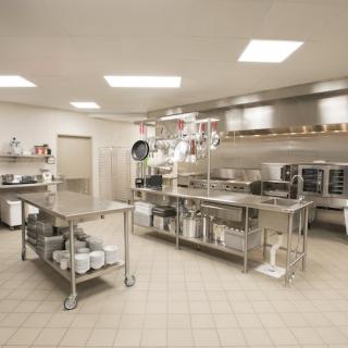A clean and organized commercial kitchen with stainless steel appliances and surfaces.