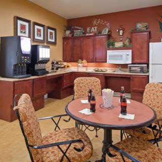 A cozy kitchen and dining area with a table set for refreshments, surrounded by modern appliances.
