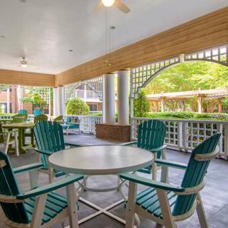A cozy outdoor seating area on a covered patio with a view of the garden.