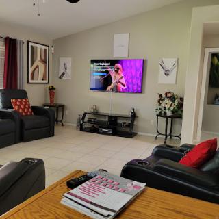 A cozy living room setup featuring comfortable seating and a television displaying vibrant colors.