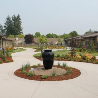 A beautifully landscaped courtyard with pathways and a central decorative urn.