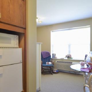 A cozy living space with a kitchen area, featuring a window letting in natural light.