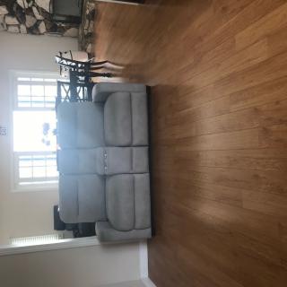 A cozy living room with a plush sofa and hardwood flooring.