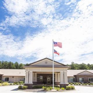 A building with flags in front under a partly cloudy sky.