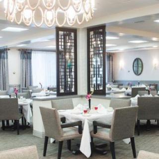 An elegant restaurant dining area with modern decor and a stylish chandelier.