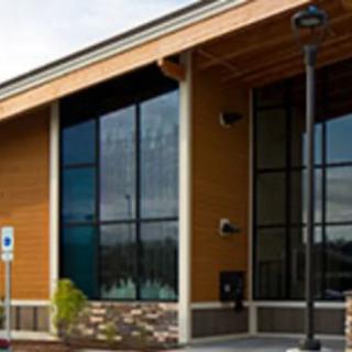 A modern building with large glass windows and a wooden exterior.