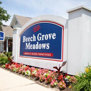 Entrance sign for Beech Grove Meadows surrounded by colorful flowers.