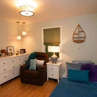A cozy bedroom with stylish decor, featuring a comfortable armchair and warm lighting.