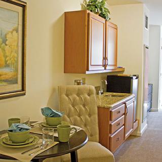 A cozy kitchenette with a round dining table set for two.