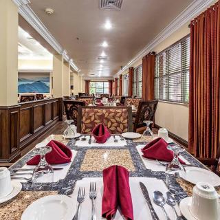 An elegantly set dining table in a spacious restaurant with neatly arranged napkins and cutlery.