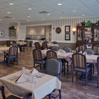 A quiet restaurant dining area with neatly arranged tables covered in tablecloths.