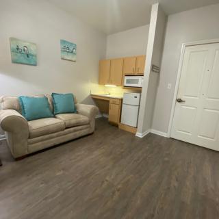 A cozy living area with a sofa and kitchenette.