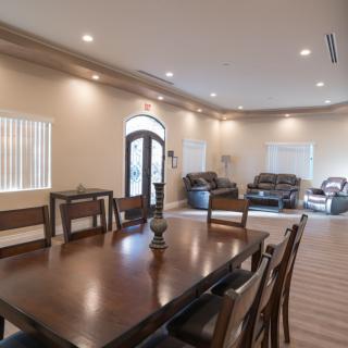 A spacious open-concept living and dining area with elegant furniture and warm lighting.