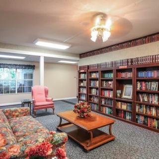 A cozy library with bookshelves and comfortable seating.