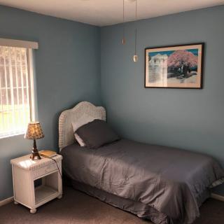 A cozy bedroom with a single bed and nightstand.