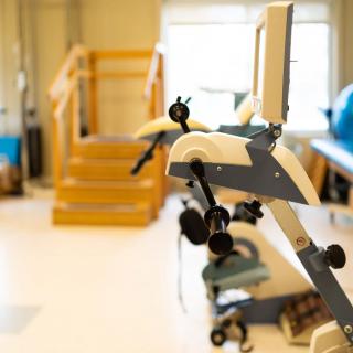 A physical therapy gym featuring exercise equipment and a staircase for rehabilitation exercises.