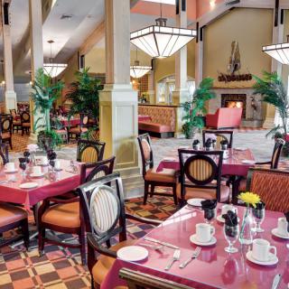 A beautifully decorated restaurant interior featuring elegantly set tables and plush seating.