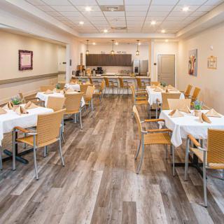 A modern dining area with neatly arranged tables and wooden chairs.