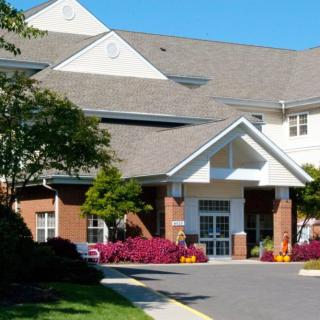 A well-maintained building entrance with colorful flowers and landscaping.