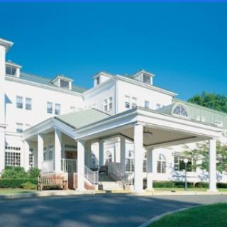 A charming hotel entrance framed by a clear blue sky.